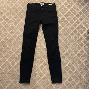 Black frame jeans with one distressed knee on left side